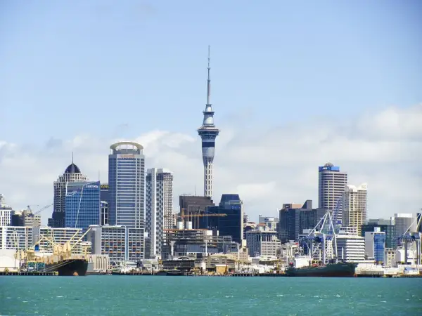 Skyline de Auckland, Nueva Zelanda, con la Sky Tower y barcos en el puerto. ¡Un destino ideal cuando viajar a Nueva Zelanda!
