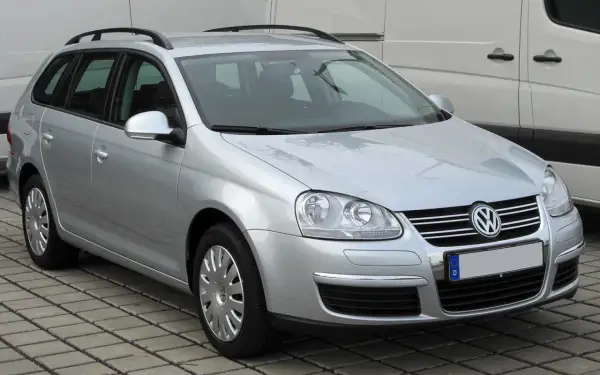 Srebrny Volkswagen Golf 5 Variant z relingami dachowymi, zaparkowany na kostce brukowej.