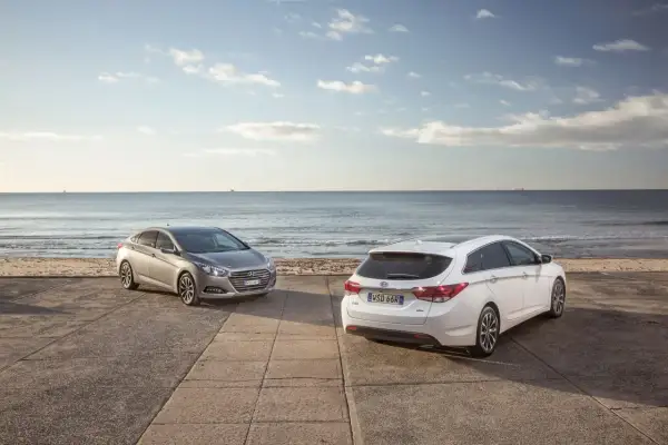 Dwa Hyundai i40, sedan i kombi, stoją nad brzegiem morza. Wiele pozytywnych hyundai i40 opinie potwierdza ich wszechstronność.
