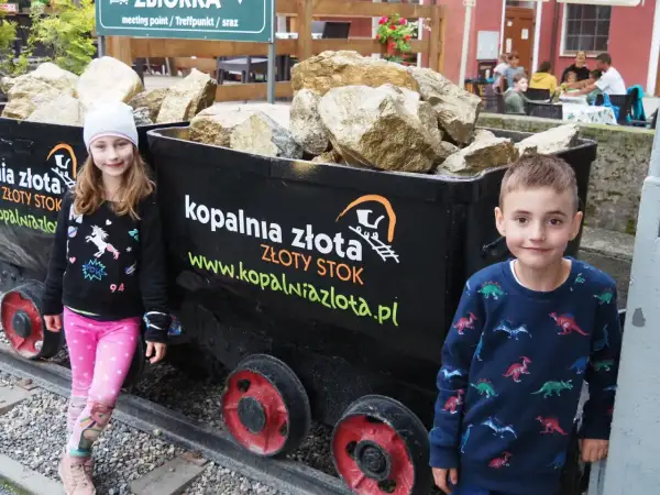 Dzieci przy wagonikach z "złotem" w Kopalni Złota w Złotym Stoku. Atrakcje dla całej rodziny.
