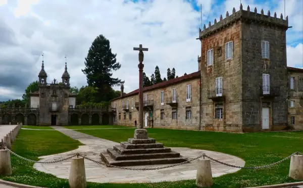 Pazos en Galicia: un cruceiro se alza en el patio de un complejo señorial con torreón y capilla.