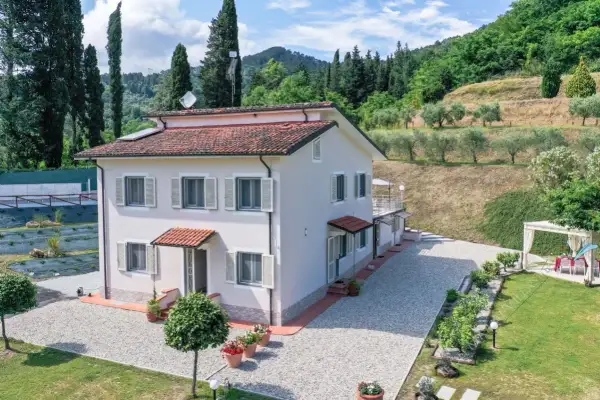 Villa unifamiliare immersa nel verde, con un ampio giardino, uliveto e vista collinare.