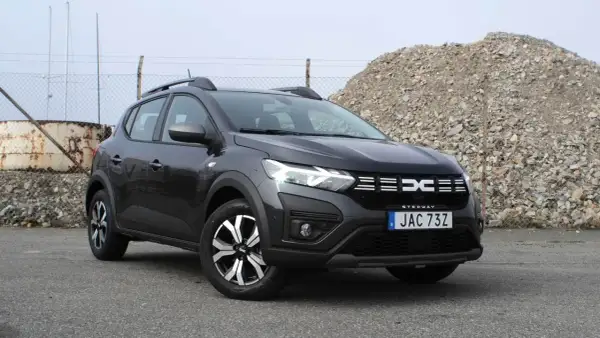 En mörkgrå Dacia Sandero Stepway står parkerad utomhus. Bilen är redo för ett däcktest.