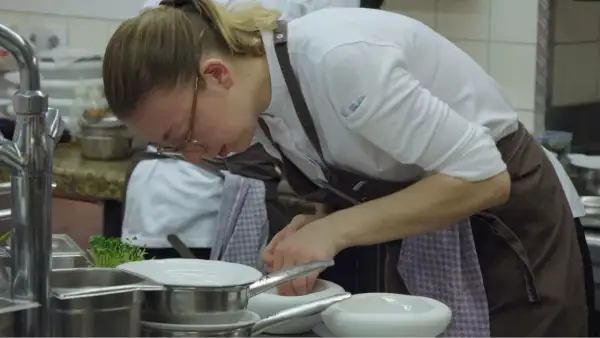Chef prepara ingredientes en un mortero, escena digna de películas sobre cocina.
