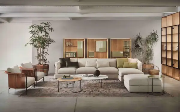 Soggiorno moderno con divano componibile beige, poltrone in midollino e pareti color tortora chiaro e scuro.