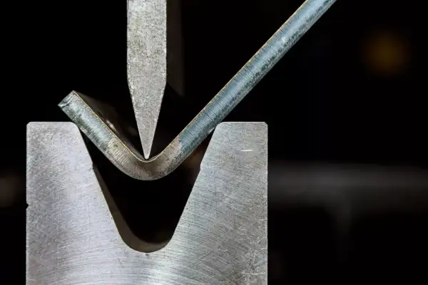 Precyzyjna obróbka plastyczna metali: gięcie blachy pod naciskiem stempla.