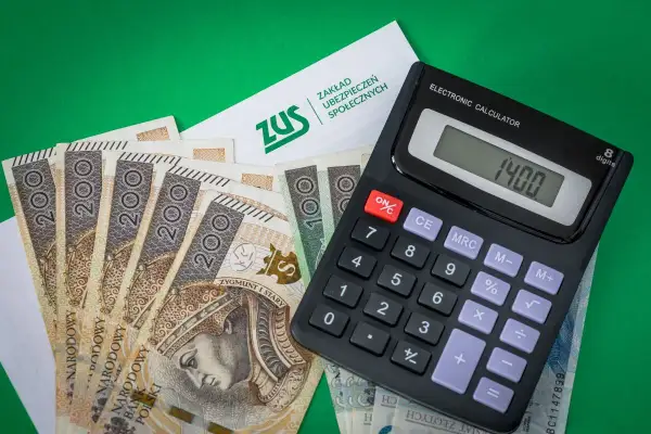 ZUS, banknoty 200 zł i kalkulator pokazują podstawę wymiaru składki na ubezpieczenie emerytalno-rentowe.