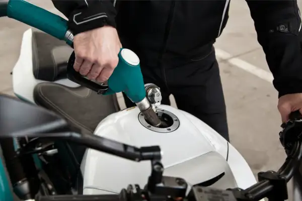Tankowanie białego motocykla. Zastanawiasz się, ile pali motor 125?