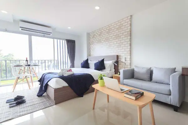 Camera da letto moderna con condizionatore posizionato strategicamente sopra la porta finestra per un comfort ottimale.