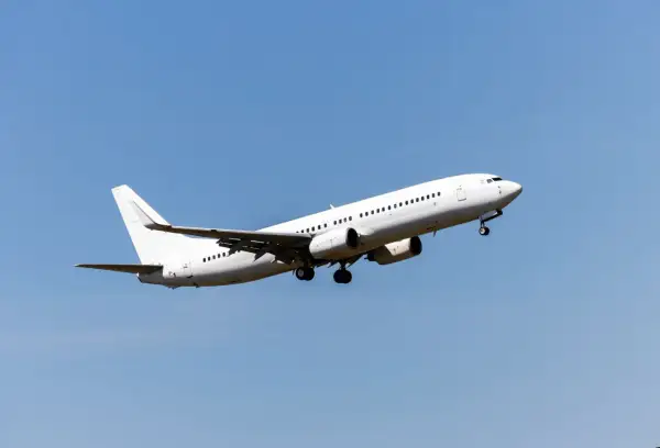 Ein weißes Flugzeug steigt in den blauen Himmel auf. Die Frage, wie hoch fliegt ein Flugzeug, bleibt offen, aber dieser Anblick lässt die Fantasie fliegen.