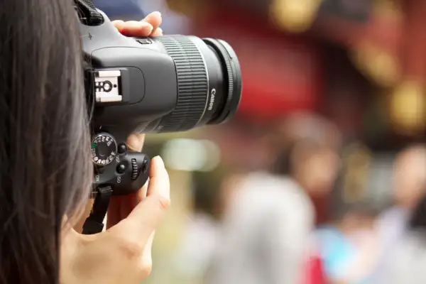 A person's hands hold a Canon digital camera, ready to capture a moment. This image is a great visual for anyone learning how to buy a digital camera.