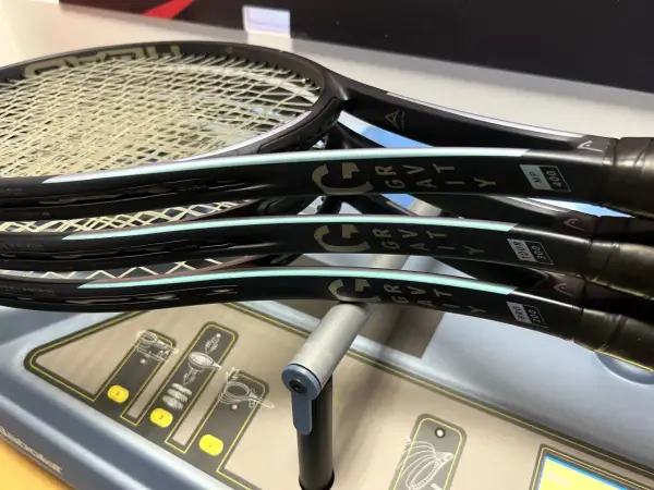 Tre racchette Head Gravity MP, pronte per essere incordate su una macchina Babolat.