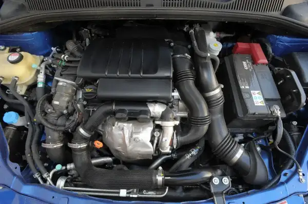 Silnik samochodowy Suzuki SX4 z widocznymi przewodami, akumulatorem i elementami układu dolotowego.
