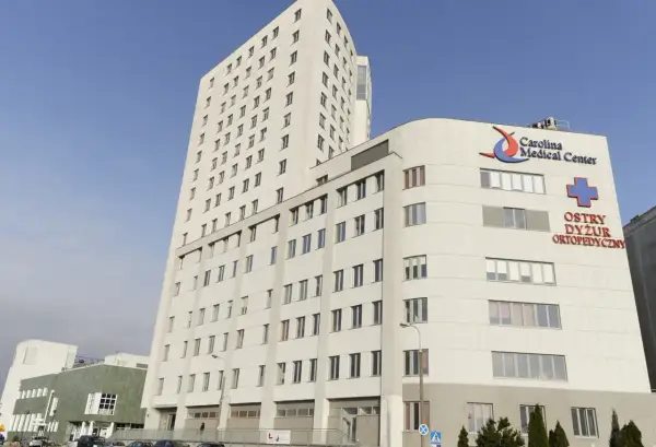 Nowoczesny budynek Carolina Medical Center w Warszawie z napisem "Ostry Dyżur Ortopedyczny".