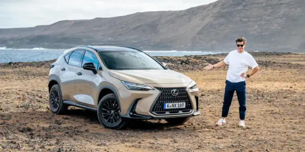 Mężczyzna prezentuje jeden z najnowszych lexus suv modele na tle surowego krajobrazu z morzem i górami.