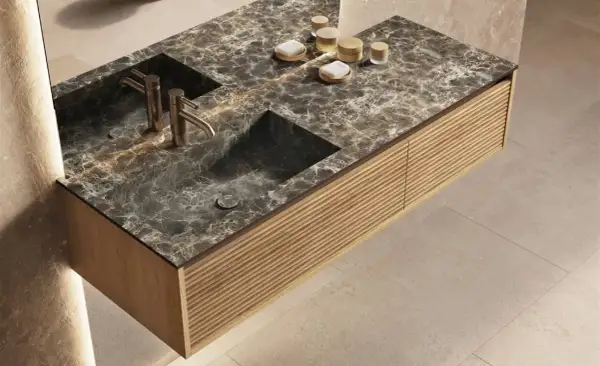Élégante salle de bain marbre et parquet. Meuble suspendu avec double vasque en marbre sombre, robinetterie dorée et façade en bois texturé.