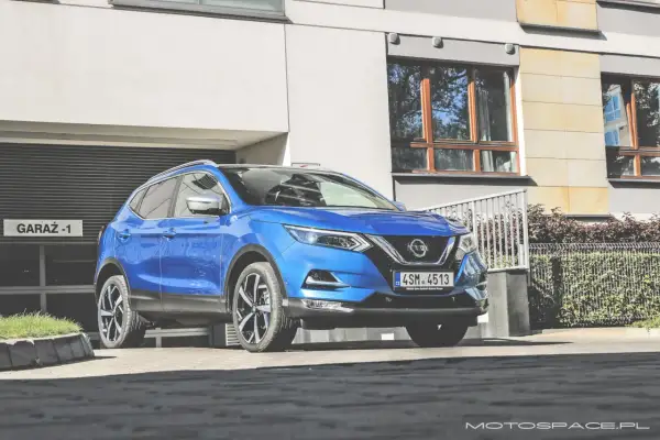 Niebieski Nissan Qashqai 1 parkuje przed garażem.