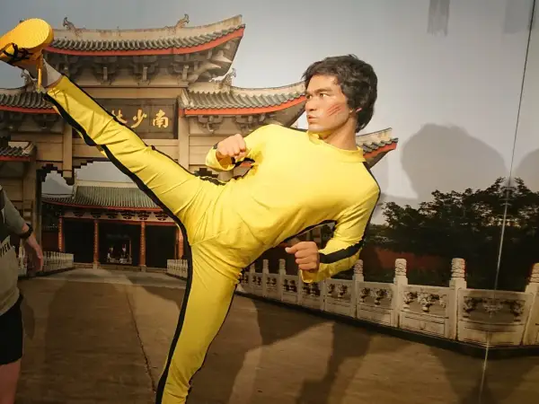 Bruce Lee w żółtym dresie wykonuje kopnięcie w powietrzu. Figura wosku w muzeum figur woskowych w Jastrzębiej Górze.