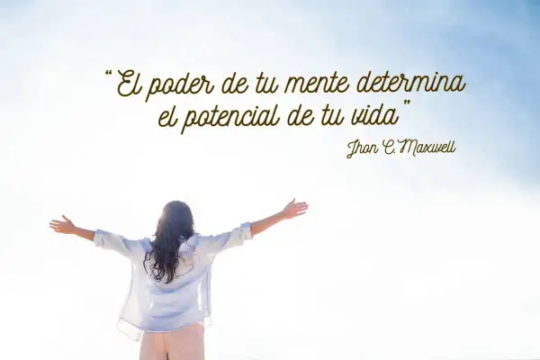 Mujer con brazos extendidos bajo un cielo azul, inspirada por sabias frases de psicología positiva: "El poder de tu mente determina el potencial de tu vida".