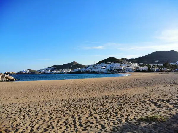 Playa de San José, con casas blancas en la ladera y el mar azul. ¡Qué carallo de vista!