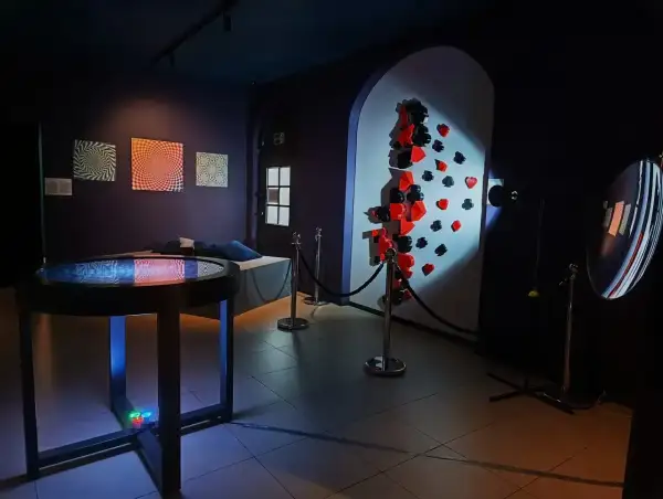 W muzeum iluzji Warszawa zobaczysz optyczne triki i instalacje, jak ściana z kartami i stołem z efektem wodnym.