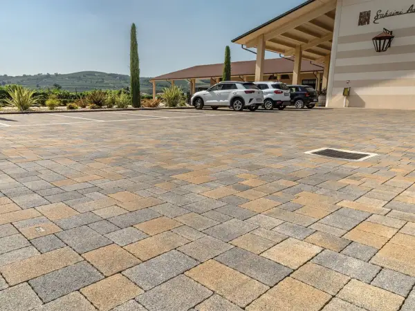 Parcheggio con pavimentazione in autobloccanti carrabili, ideale per esterni. Le auto sono parcheggiate su un pavimento resistente e bello.