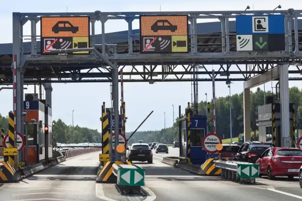 Kolejka samochodów na bramkach autostradowych. Jeden z pojazdów, jakby chciał wystartować w wyścigu dragster, czeka na zielone światło.