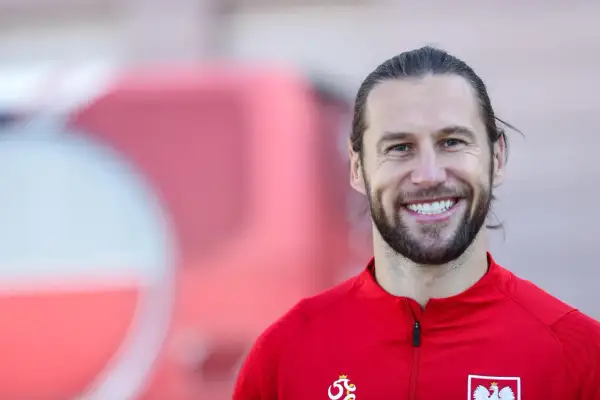 Uśmiechnięty Grzegorz Krychowiak w czerwonej bluzie reprezentacji Polski. Jego wiek to doświadczenie na boisku.