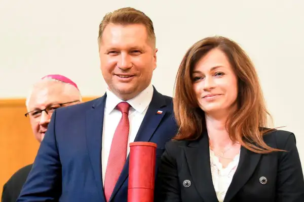 Przemysław Czarnek z żoną, Katarzyną, podczas uroczystości. Z tyłu widoczny biskup.