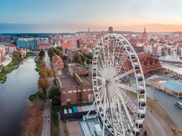 Widok na miasto z diabelskim młynem w Gdańsku. W tle rzeka Motława i zabytkowa zabudowa.