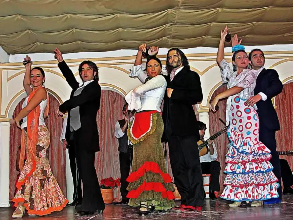 Artistas en escena, aprendiendo flamenco con pasión. Bailarines y músicos crean un espectáculo vibrante.