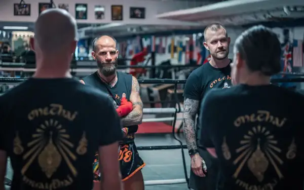Tränare och fighters i en ring, alla bär tröjor med texten "onechai muaythai".