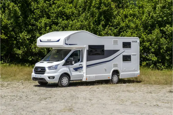 Nowy biały kamper z niebieskimi akcentami, idealny na wakacje. Sprawdź ofertę camper wypozyczenie.