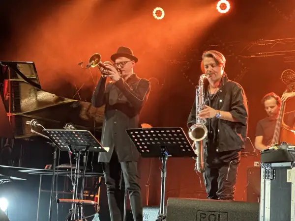 Trębacz i saksofonista na scenie, tworząc niepowtarzalny klimat jazzu w Polsce.