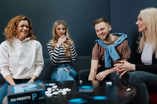 Grupa przyjaciół śmieje się, grając w grę słowną "Po Prostu P".