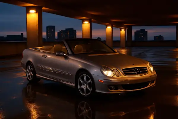 Srebrny kabriolet Mercedes CLK W209 na mokrym parkingu. Dane techniczne tego modelu są imponujące.