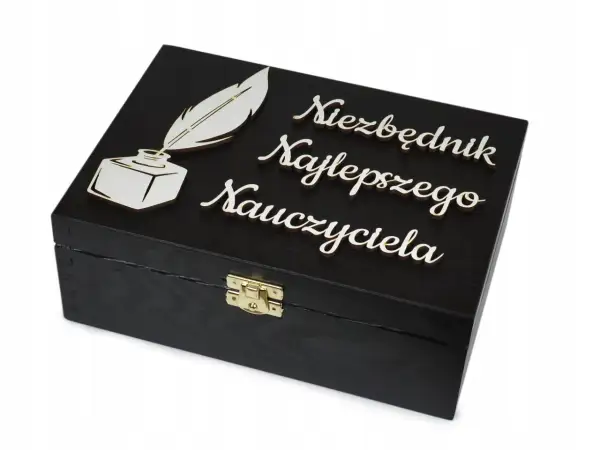 Czarna szkatułka z piórem i kałamarzem, ozdobiona napisem "Niezbędnik Najlepszego Nauczyciela". Idealna dedykacja dla nauczyciela.