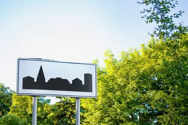 Znak teren zabudowany z sylwetką miasta. Wjeżdżamy do miasta, gdzie czekają nas miejskie krajobrazy.