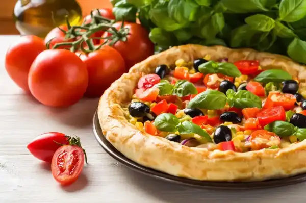 Pyszna pizza z pomidorami, oliwkami i kukurydzą, gotowa do podania. Ile piec pizze? Ta wygląda idealnie!