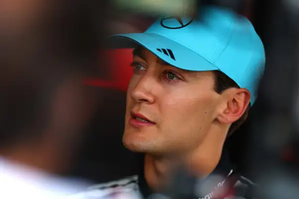 George Russell, piloto de F1, con gorra azul y mirada concentrada.