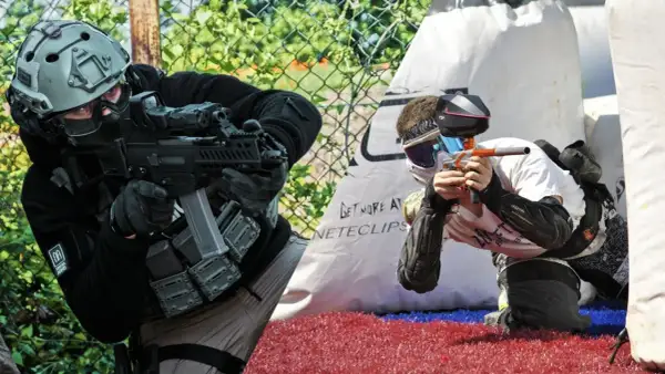 Dos jugadores, uno en airsoft paintball, se preparan para la acción.