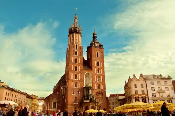 Bazylika Mariacka w Krakowie, jedno z najpiękniejszych miejsc historycznych w Polsce, na tle błękitnego nieba z chmurami.