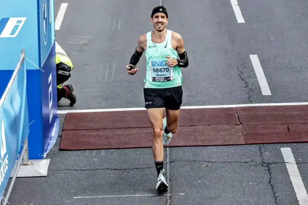 Nicolas franchit la ligne d'arrivée, son kit marathon impeccable. Il a l'air épuisé mais heureux.