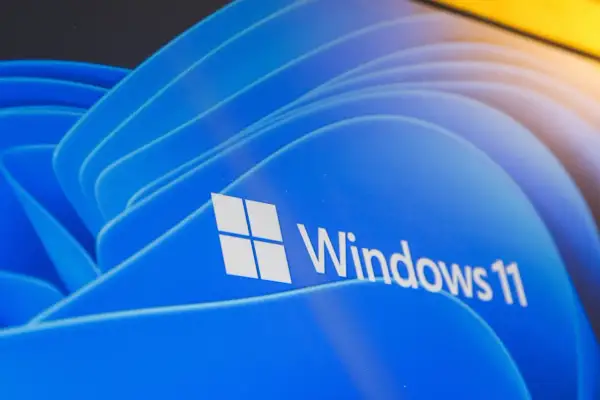 Nawet stary komputer może działać z Windows 11, pokazany na niebieskim tle z logo.