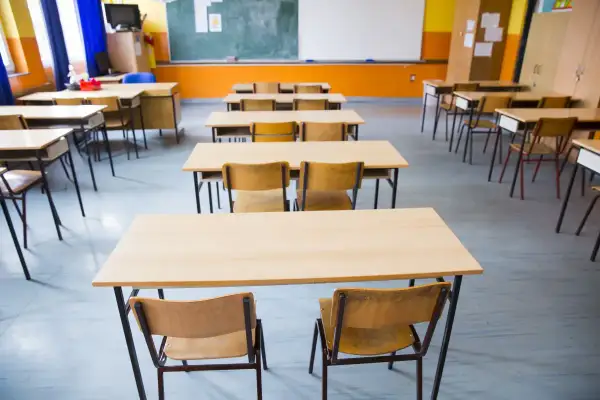Puste ławki i krzesła w sali lekcyjnej. Obowiązek szkolny trwa do 18 roku życia.