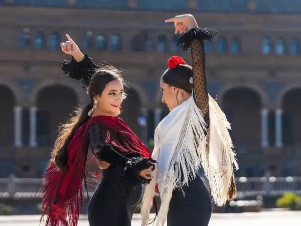 Dos mujeres bailan flamenco con mantones. ¡Perfecto para clases de flamenco para adultos!
