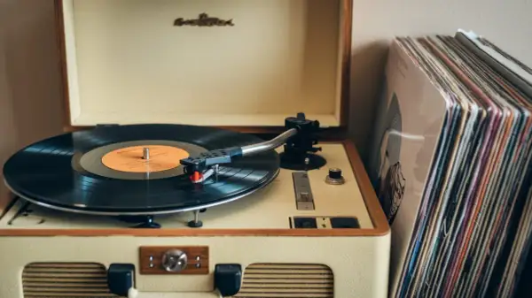 Retro gramofon z płytą winylową i stosem okładek. To jak pierwszy gramofon, który przywraca wspomnienia.