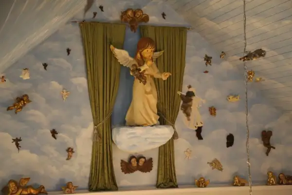 Engelsfiguren schweben vor einer Wolkenwand im **Engelmuseum Engelskirchen**. Eine große Engelsfigur thront auf einer Wolke.