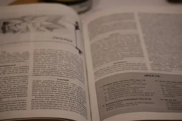En öppen bibel med texten "Jesaja" synlig. En bok i bibeln som berättar om Guds budskap.