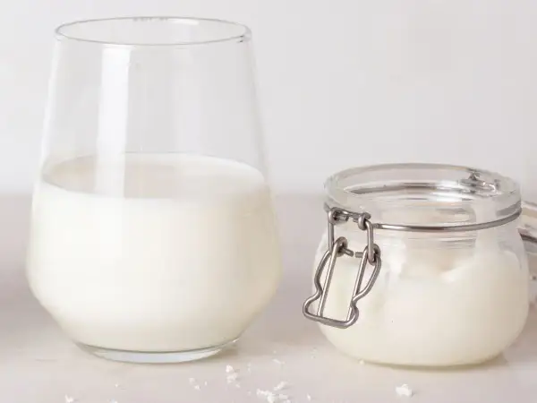 Un verre de lait et un pot de lait de beurre, prêts pour une recette gourmande.